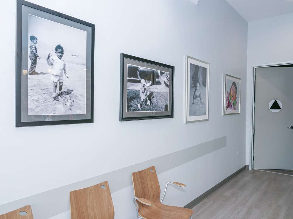 Hallway lined with framed childhood photographs of our doctors